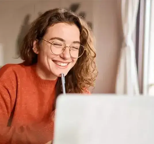 Mulher sorrindo em frente ao NoteBook